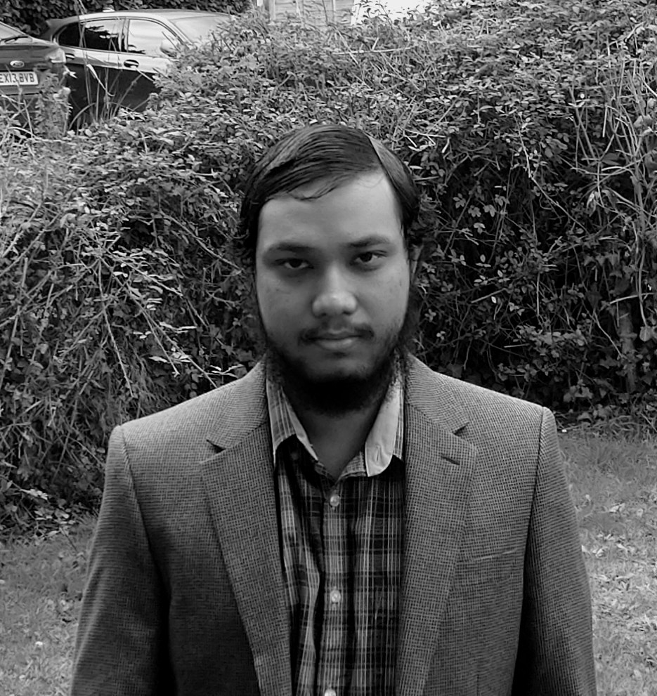 A greyscale picture of Mihi Hasan, dressed in a shirt and blazer.